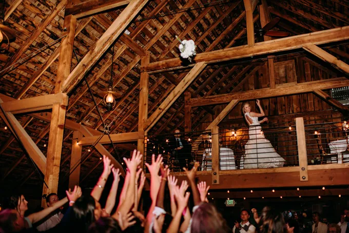 Wedding guests celebrate inside the wooden barn