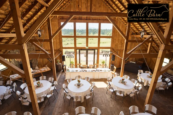 Tables arranged beneath the barn’s timber rafters