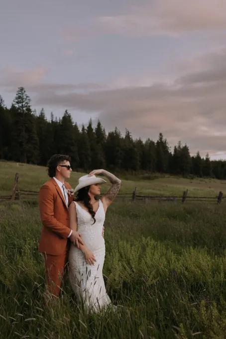 A couple standing in a field at sunset