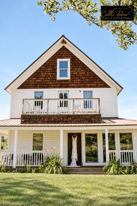White ranch house framed by trees